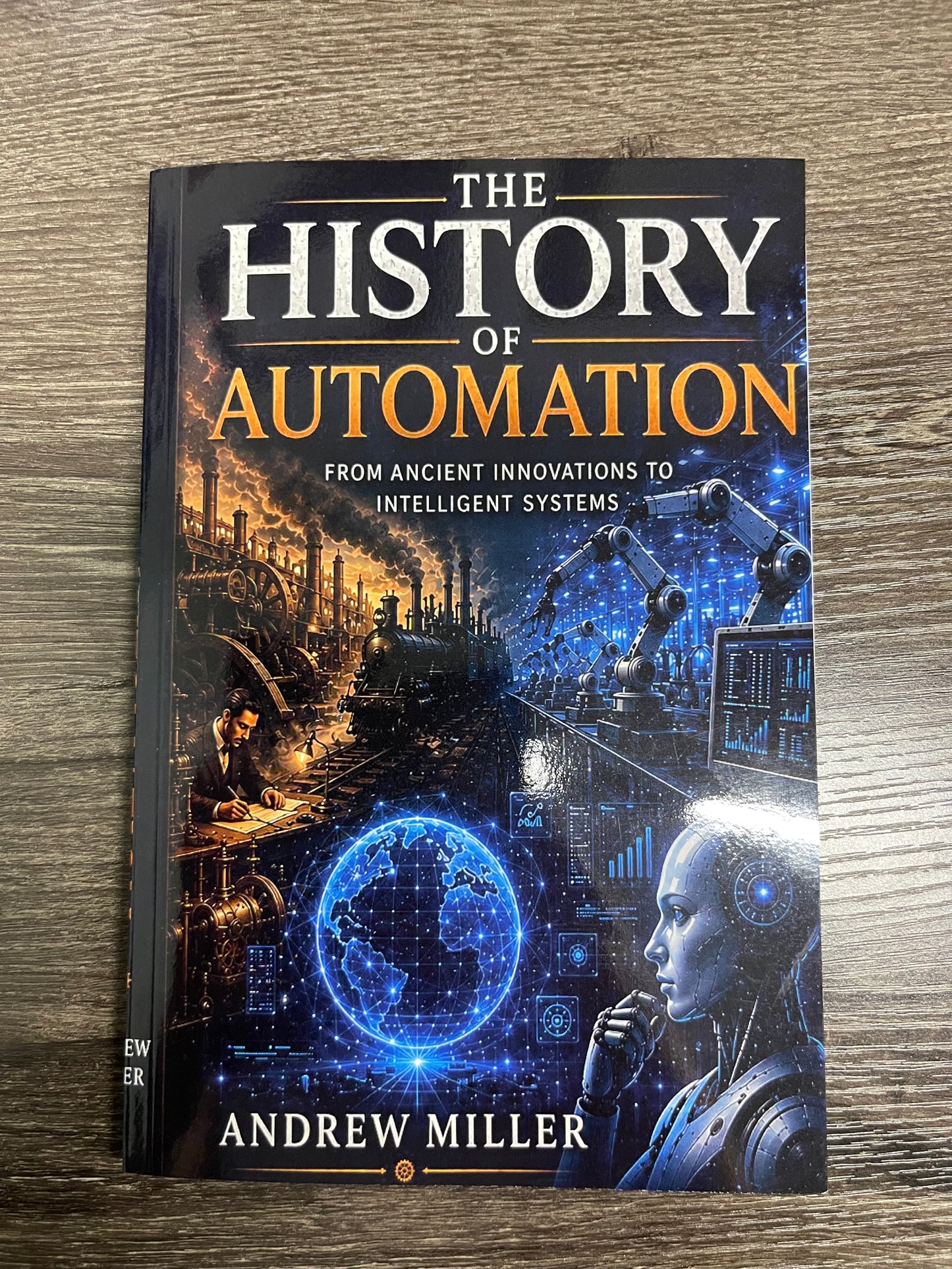 The book 'The History of Automation' by Andrew Miller, featuring a dark cover with blue and orange text and an illustration of a futuristic industrial scene and robot, placed on a wooden surface.